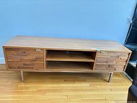 Front view showing overall design, cabinet doors, open shelving and metal legs