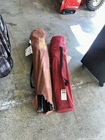 Two fabric carry bags with chairs inside, brown and red