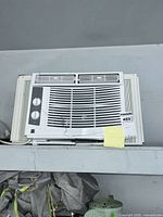 Front view showing grille, control knobs, and brand label