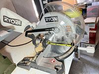 Full view of Ryobi compound miter saw showing attached dust bag and overall wear