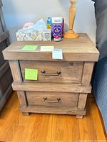 Front view of nightstand with items on top, drawers closed