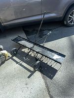 Full view of dethatcher showing frame, wheels, tow bar and tines