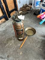 Extinguisher and bed warmer shown together on concrete floor