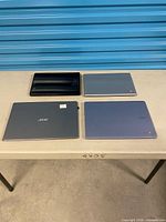 Four closed Acer laptops on table
