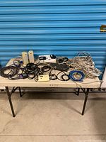 Entire assortment of cables, speakers, mouse, power bar and Icron units on table