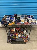 Overall view of table with mixed video game boxes, discs and manuals