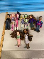 Group shot of all nine dolls with ruler for scale