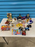 Table view showing full assortment of toys including LEGO set, Batman, vehicles and accessories