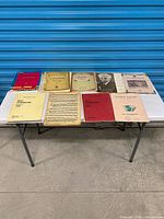 Full table view of entire lot showing all music books and loose sheets
