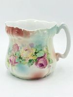 Front view of porcelain creamer showing floral motif and ombré colouring