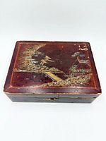 Closed box top showing landscape decoration and wear