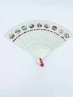 Full view of the opened plastic filigree souvenir fan