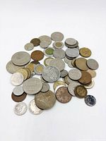 Pile of mixed world coins spread on white background
