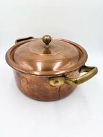 Side view of copper pot with lid and handles