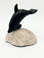 Front view of soapstone dolphin mounted on stone base