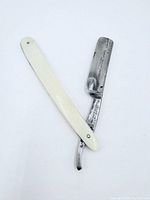 Straight razor fully opened showing blade and ivory-coloured handle