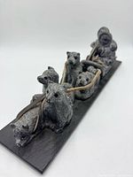 Angled view showing entire stone sculpture with Inuit on sled and four dogs