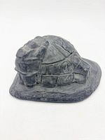 Side view of grey stone igloo carving showing block detailing and entrance