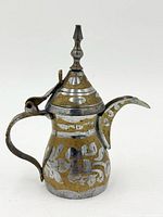 Side view of brass Dallah showing floral inlay, handle, spout, and lid