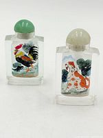 Front view showing rooster and dog painted scenes on both bottles