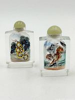 Front view showing both inside-painted animal scenes and stoppers