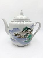 Side view of teapot showing landscape scene and spout