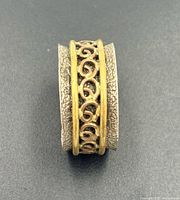 Top view of sterling silver ring with copper scroll spinner band
