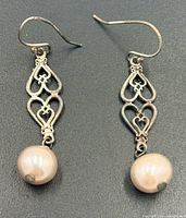 Front view of both earrings showing silver heart motif and pearls