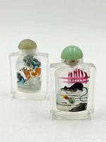 Front view showing both snuff bottles, dog scene left, rat scene right