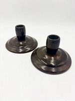 pair of dark stained wooden candlestick holders top view