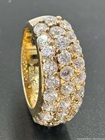 Angled view showing three rows of round brilliant pavé cubic zirconia and gold-tone band
