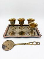 full set: four egg cups on tray with pierced spoon in foreground