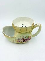 Side view showing floral decal, handle, overall form