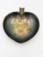 Top view showing heart-shaped pewter ashtray and brass flower inlay