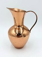 Full view of hammered copper pitcher showing handle, spout and body