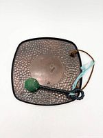 Front of square hammered copper gong, mallet resting