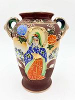 Front view showing figural and floral moriage decoration and handle style