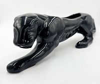 Left front perspective of glossy black ceramic panther planter showing crouching pose and facial detail