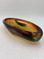 Angled side view showing amber to green sommerso color layers and oval shape