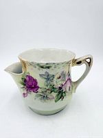 Front view of floral scuttle shaving mug showing spout, handle and rose pattern