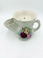 Front view showing rose bouquet decal, brush rest spout, drainage holes