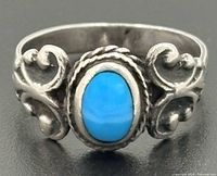 Front view showing turquoise cabochon, rope bezel, scroll shoulders