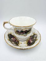 Paragon Chippendale teacup on matching saucer showing exterior scenic panels and gilt trim