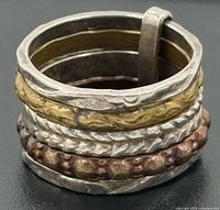 Ring angled view showing silver, brass, copper bands