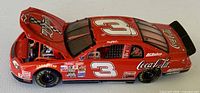 Left front three-quarter view, hood open showing engine detail, red Coca-Cola #3 livery