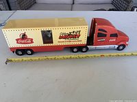 Left side view of the semi-truck showing cab, trailer graphics, and size scale