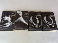 Four paperback novels laid out, showing all titles
