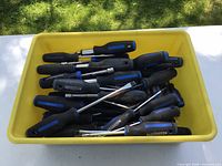 Yellow bin filled with numerous Mastercraft screwdrivers
