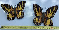 both ceramic butterflies beside tape for scale