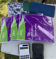 Overall lot view showing calculators, three ruled paper packs and pencil cases